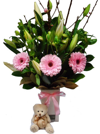 Lovely lilies, gerberas, alstomeria in a ceramic vase with a cute teddy can be made to order for a baby girl or boy.