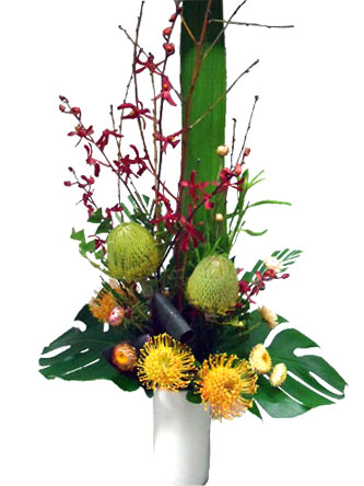 Seasonal native and orchids stunning flower arrangement in a ceramic vase.
